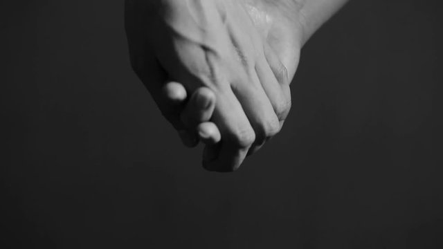 close up man and woman hand touching holding together on blurred background.