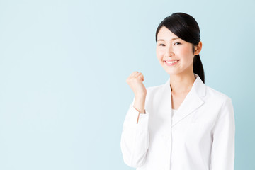 portrait of young asian nurse isolated on blue background
