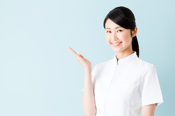 portrait of young asian nurse isolated on blue background