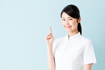 portrait of young asian nurse isolated on blue background