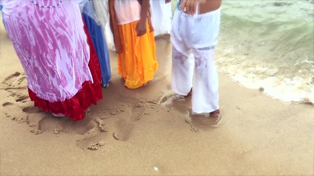 Worshippers in ceremonial dress at the Festival of Yemanja splash in slow motion in the waves on the beach at Rio Vermelho, in Salvador, Brazil