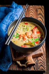 Hot Tom Yum soup in black bowl with chopsticks