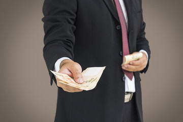 scene of busineesman give the money to you on gray background - can use to display or montage on product