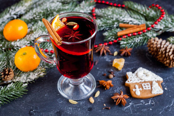 Christmas mulled wine with spices in cup on dark background