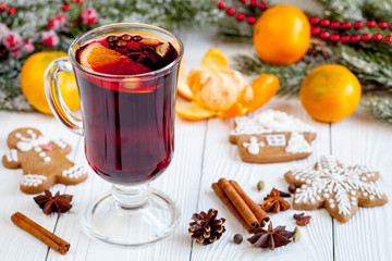 Christmas mulled wine with spices in cup on wooden background