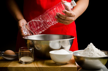 Preparation bread cooking,holding the bottle of water to mixing