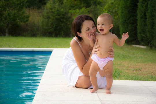mother with a cute baby sitting by the poo
