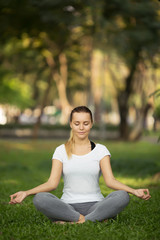 Young woman meditation in city park. Yoga exercise