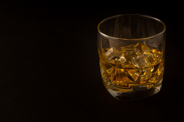 Glass of whiskey on a dark background