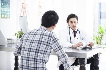 The doctor is diagnosing young men in the examination room