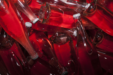 Rose wine in see-through bottles, arranged in a pile 