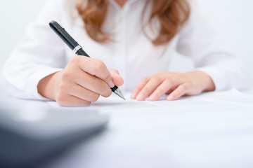 Business women filling contract at desk.