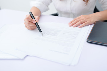 Business woman filling information on document.