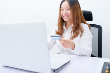 Young woman using credit card paying on laptop.