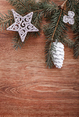 Silver Christmas ornaments and fir tree branch on a rustic wooden background. Xmas card. Happy New Year. Top view with copy space