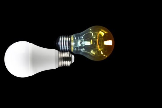 Led light bulb on dark background with Blurred incandescent light bulb and copy space on the right screen