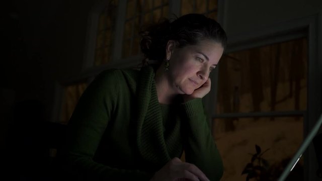 a woman using the internet alone in dark