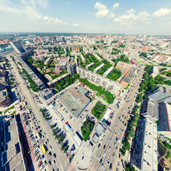 Fototapeta premium Aerial city view with crossroads and roads, houses, buildings, parks and parking lots, bridges. Urban landscape. Copter shot. Panoramic image.