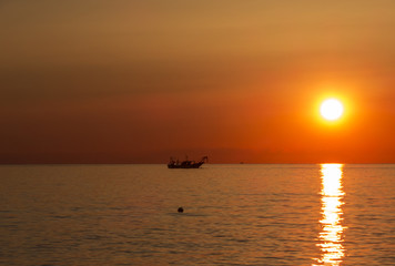 Fototapeta na wymiar Fishing boats pull their nets at the sunrise. Adriatic cost. Emilia Romagna. Italy.