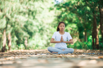 Young asian woman doing yoga in the morning at the park. Healthy