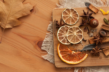 Cutting board with mixed spices and dry citrus slices on the linen tablecloth. On the wooden background . 