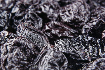 Prune close up background. Heap of glossy black prunes. Top view.