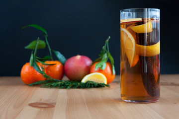 Glass with Seasonal warming drink.Cinnamon,lemon zest and some fruits.