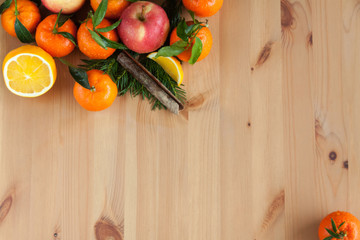 Wooden background with some mandarins,oranges,apples on it.
