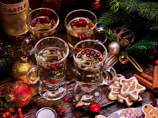 Glasses with a punch in the foreground Christmas still life. Christmas decorations and candles, Christmas cookies.