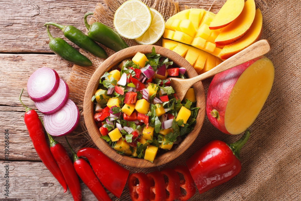 Poster Mexican Food: salsa with mango, cilantro, onions and peppers closeup and ingredients. Horizontal top view