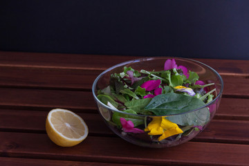 Glass bowl filled with organic superfood salad with flowers with