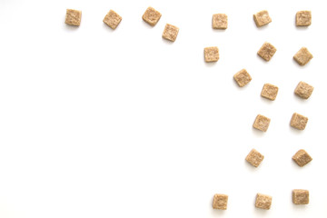 Brown sugar cubes on white background. Top view. Diet unhealty sweet addiction concept