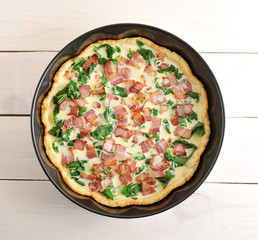 quiche, baked eggs, spinach and bacon in the baking dish