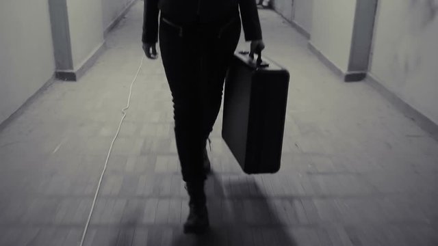 Young business woman runs away with suitcase.