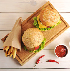 two hamburgers with fried potatoes in a paper bag and the ketchu