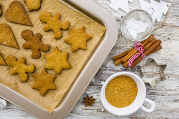 Christmas homemade gingerbreads and Christmas spices on a wooden background. 
