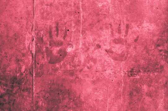 childrens hand impressions on a red reddish gray wall with scratches 