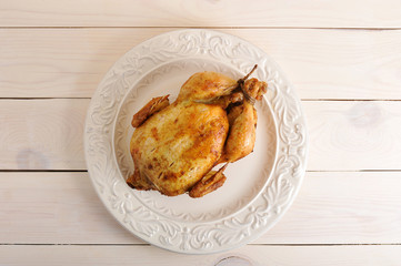 whole roasted chicken with bound feet on the plate