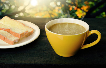 Coffee and bread at relaxation time on wooden table in morning.selective focus.