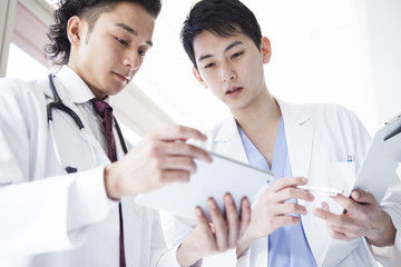 Male doctors are talking while watching electronic tablet
