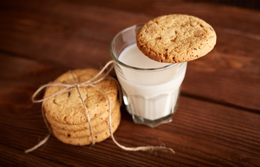 Cookies and milk. Chocolate chip cookies and a glass of milk. Vintage look. Tasty cookies and glass of milk on rustic wooden background. Food, junk-food, culinary, baking and eating concept
