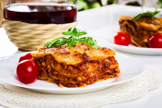 Piece of tasty hot lasagna with red wine..