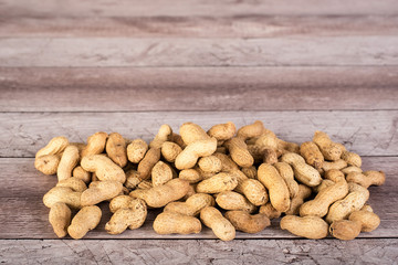 Peanuts in shells on wood background