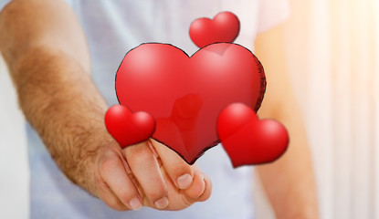 Young man touching hand drawn red heart