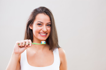 Young woman holding toothbrush. Dental hygiene concept. 
