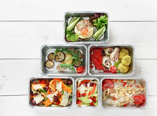 Healthy food take away in boxes, top view at wood