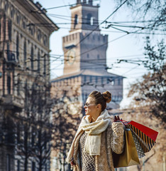 trendy traveller woman in Milan, Italy looking into distance