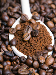 Iinstant coffee in spoon on coffee beans background
