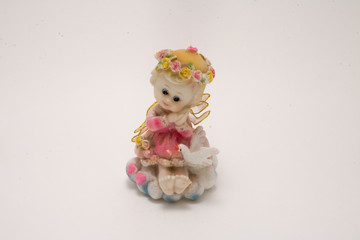 porcelain figurine angel girl in a pink dress with a pigeon isolated on white background