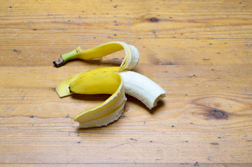 Partially peeled half eaten ripe yellow banana